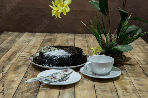 Moisture cake with topping chocolate, dry coconut with decoration on the wooden table, selective focus. photo