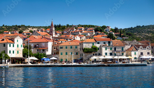 Panorama, coastline and red roofs of village Postira on island Brac in Croatia