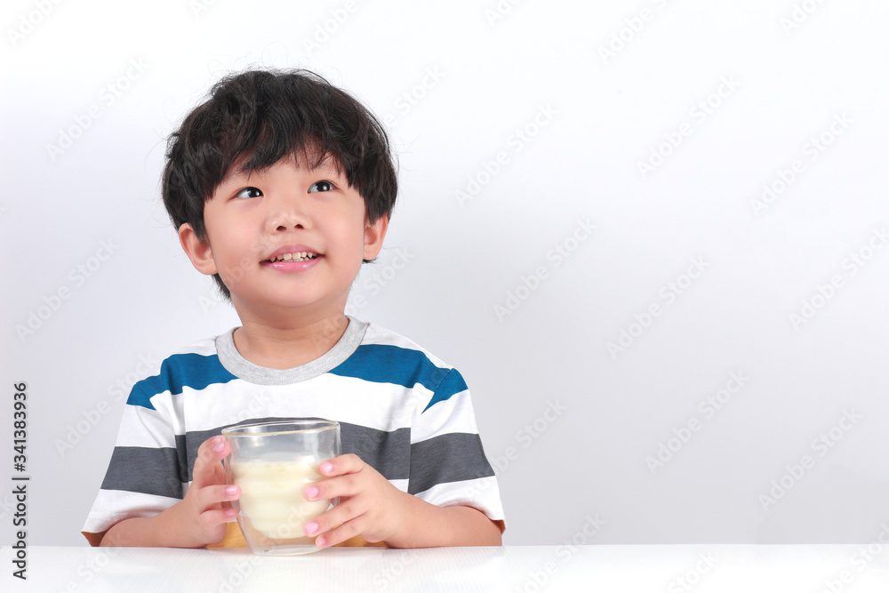 Portrait Of Smiling Boy Holding Milk Against White Background Portrait Of Smiling Boy Holding Milk Against White Background