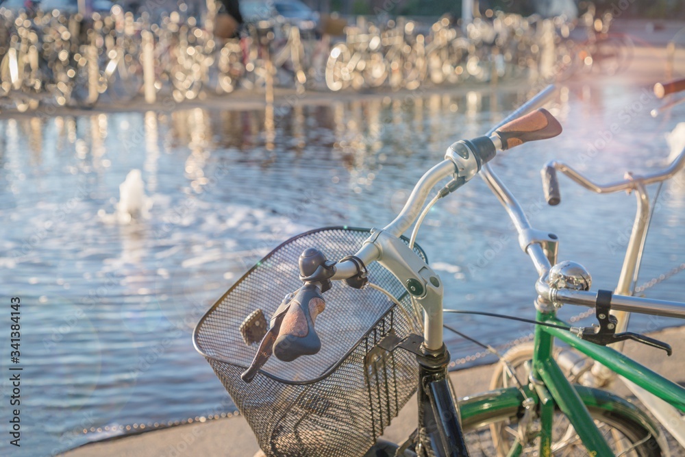 Sunny morning. Vintage bicycle with metallic basket near the water.