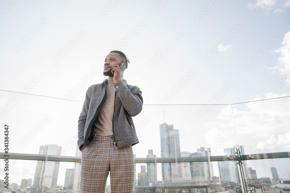 Stylish man on the phone on observation terrace with skycraper view, Frankfurt, Germany Stylish man on the phone on observation terrace with skycraper view, Frankfurt, Germany