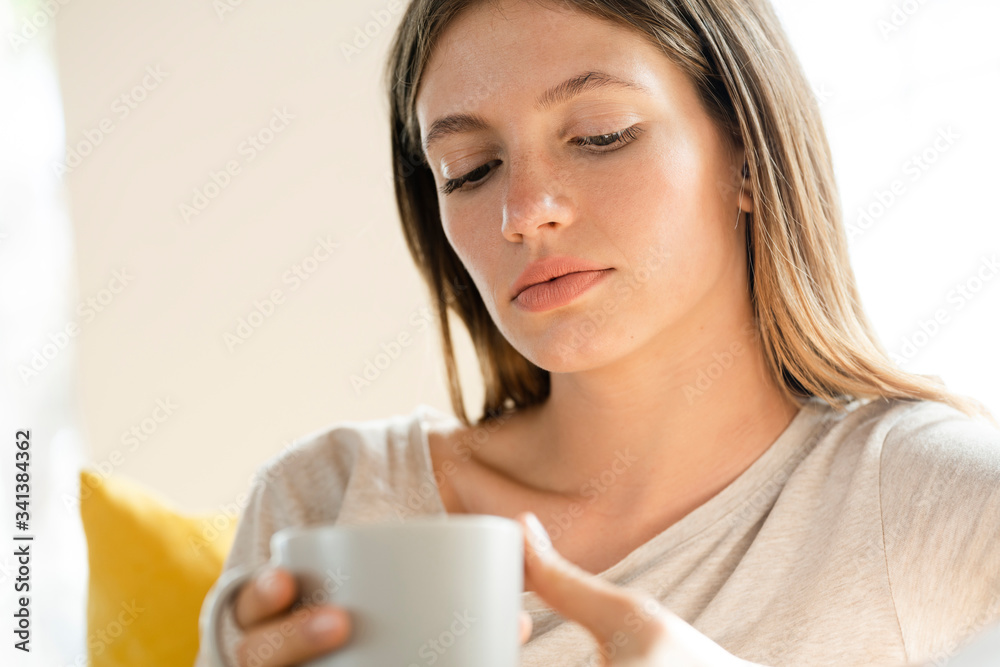 Portrait of serious young woman holding coffee mug Portrait of serious young woman holding coffee mug