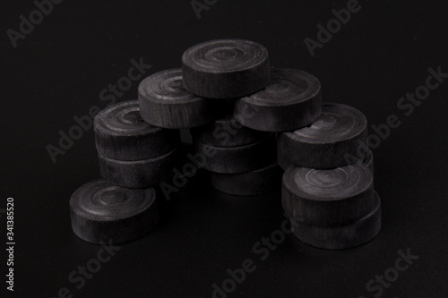 Pyramid of black chips backgammon for playing backgammon on black background. Game for recreation photo