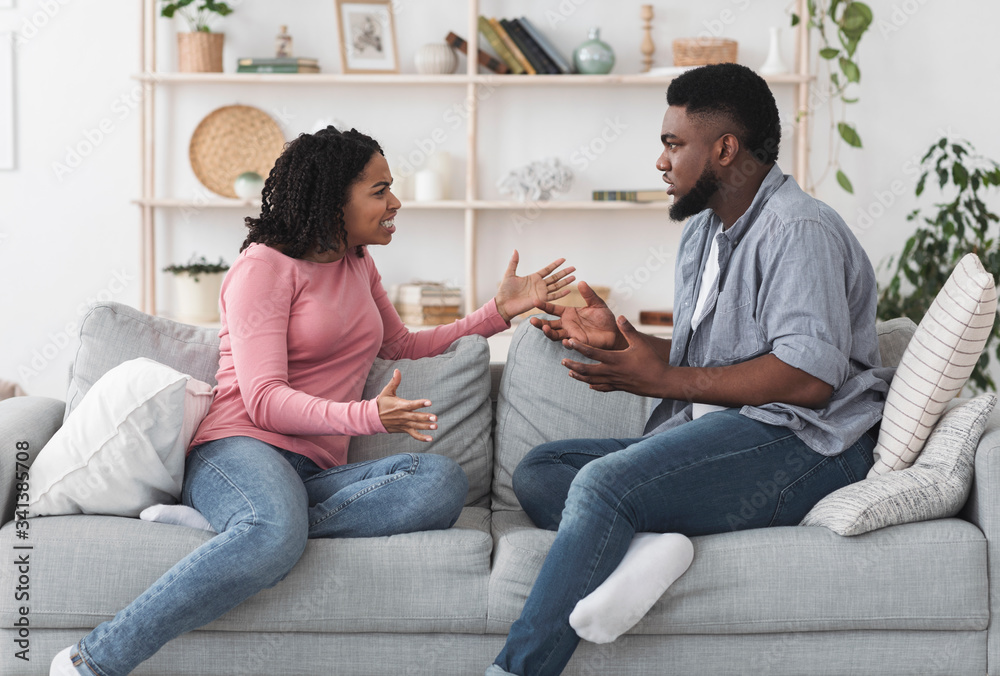 Married black couple quarreling at home, shouting and blaming each other Married black couple quarreling at home, shouting and blaming each other