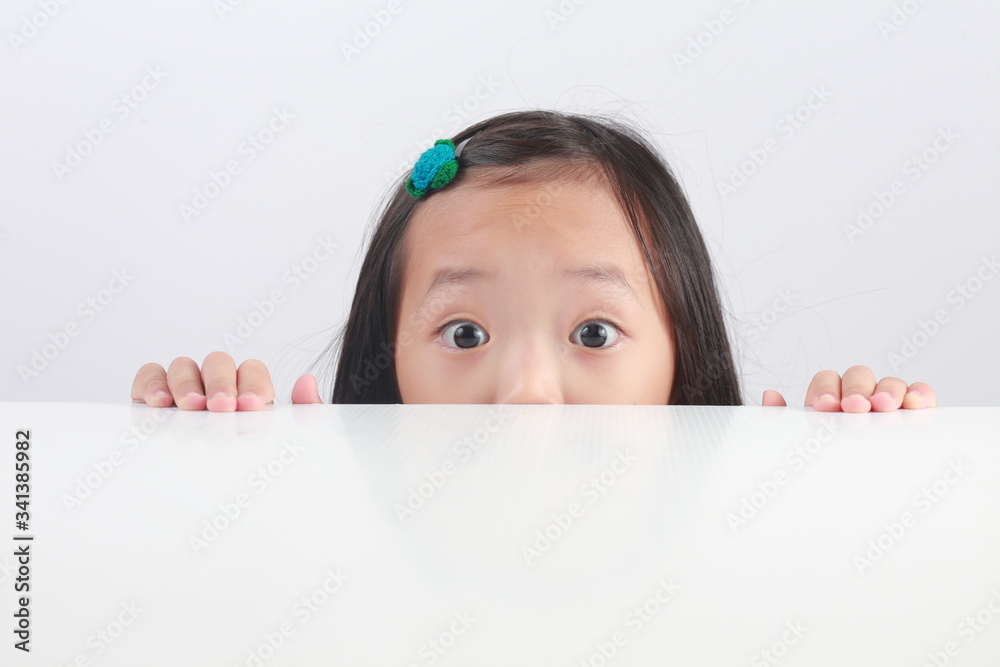 Portrait of little boy looking at the camera from under the table isolated on white background. Portrait of little boy looking at the camera from under the table isolated on white background.