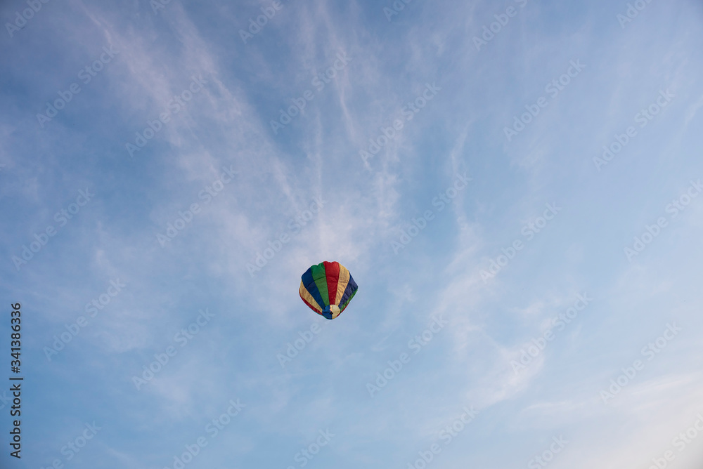  A colorful lantern/balloon is flying in the blue sky with white clouds in the afternoon of Diwali. Indian festival