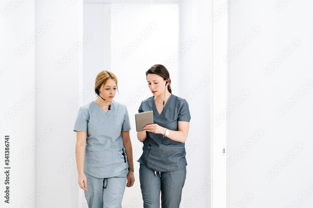Two medical secretaries with headset and tablet in medical practice Two medical secretaries with headset and tablet in medical practice