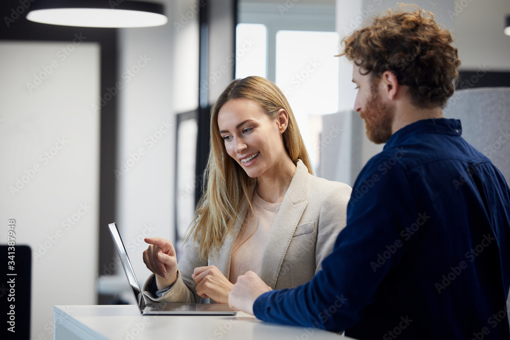 Businessman and businesswoman working together with laptop in office Businessman and businesswoman working together with laptop in office