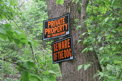 Private Property and Beware Of Dog Signs On Tree