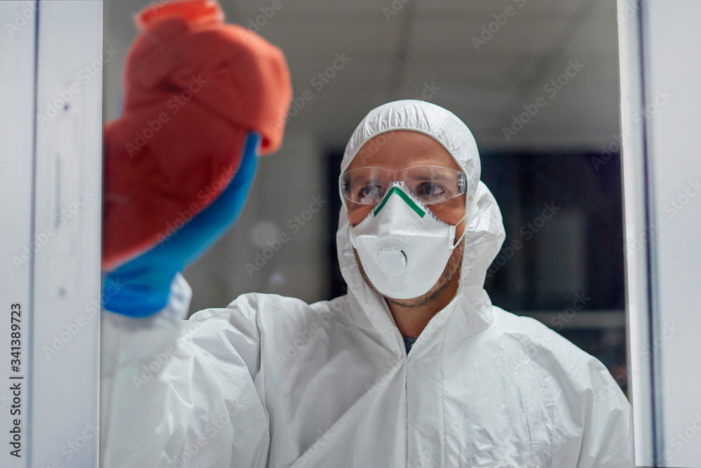 Cleaning staff desinfecting hospital against contageous virus, wearing protective clothing
