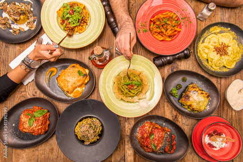 overhead shot of Italian food and hands with forks