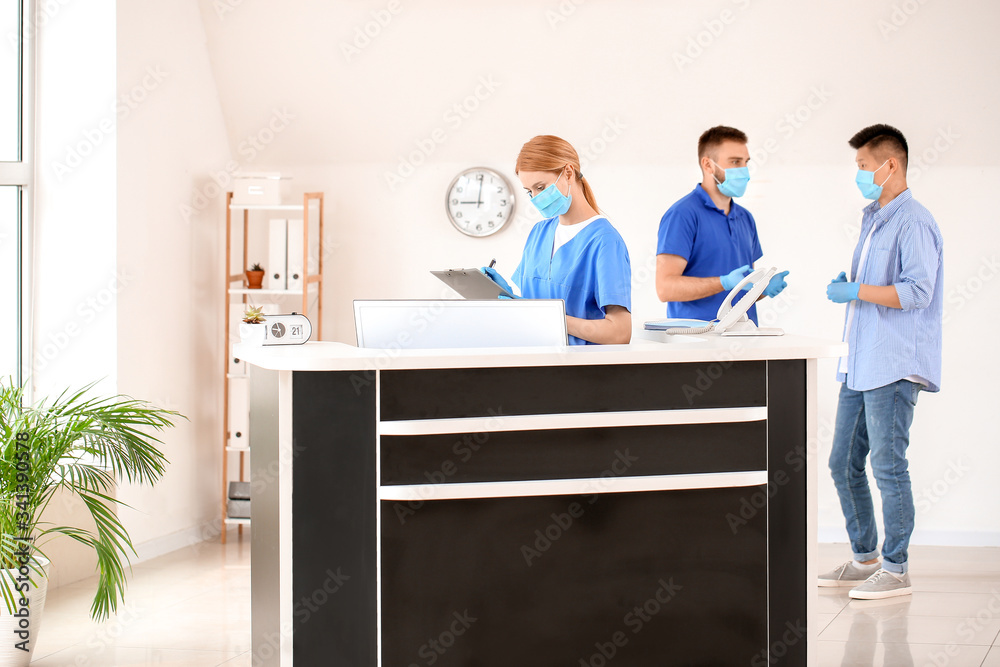 Female receptionist working at desk in clinic Female receptionist working at desk in clinic