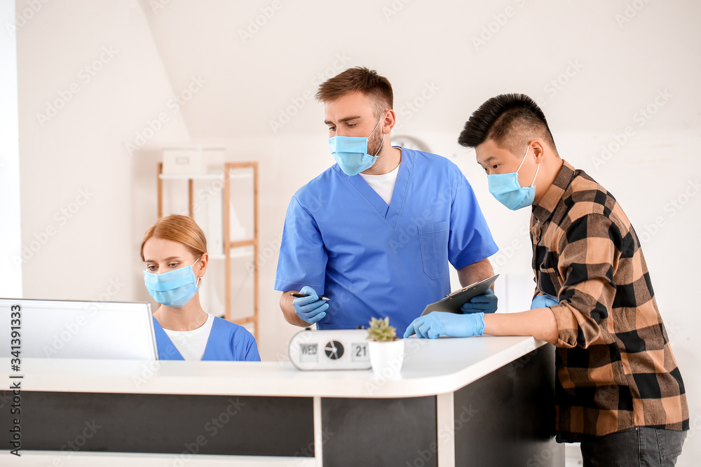Obraz premium Receptionists working with patient at desk in clinic