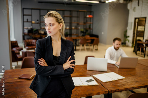 Portrait of a successful young business lady in a classic suit standing in the office