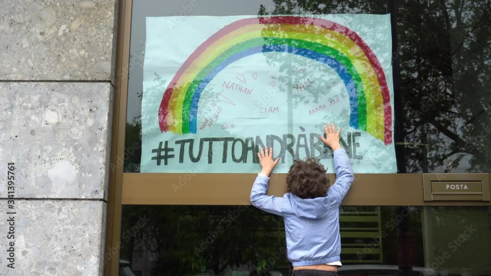 Europe, Italy , Milan  -  Boy children five years old touch  the inscription everything will be fine ( tutto andra' bene )during n-cov19 Coronavirus epidemic - quarantine life style - flash mob