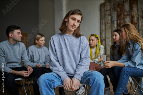 stressful caucasian male is member of alcoholics club, he want to get rid of addiction, sit apart from club and look at camera