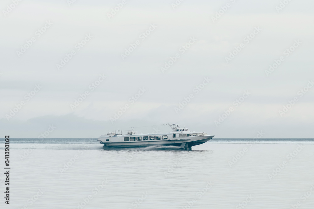 Fast soviet hydrofoil boat goes on Baikal lake at foggy summer day