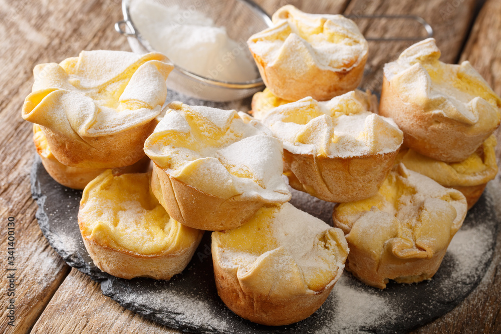 Soffioni cupcake with ricotta cheese sprinkled with powdered sugar close-up on a slate board. horizontal