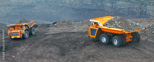 Heavy truck in a quarry transports coal loading excavator