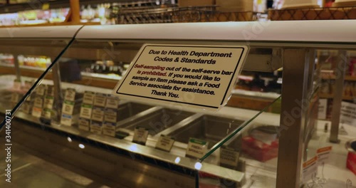 Health warning sign on food bar in grocery store due to Covid-19 pandemic