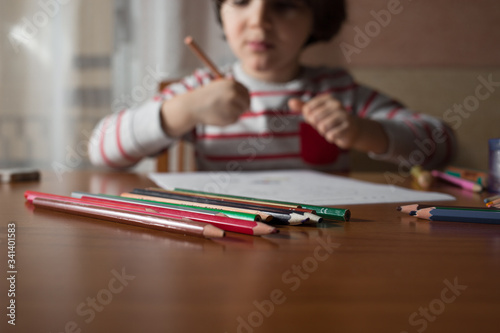 Preschooler drawing on the table in his home