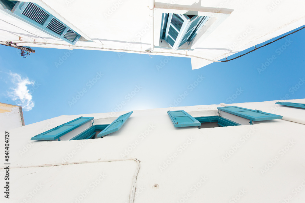 Obraz premium Classic Greek house with white wall and blue shutters
