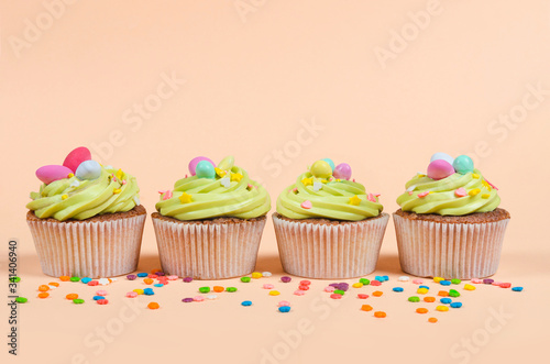 Row of bright pistachio Easter cupcakes with decorations close up