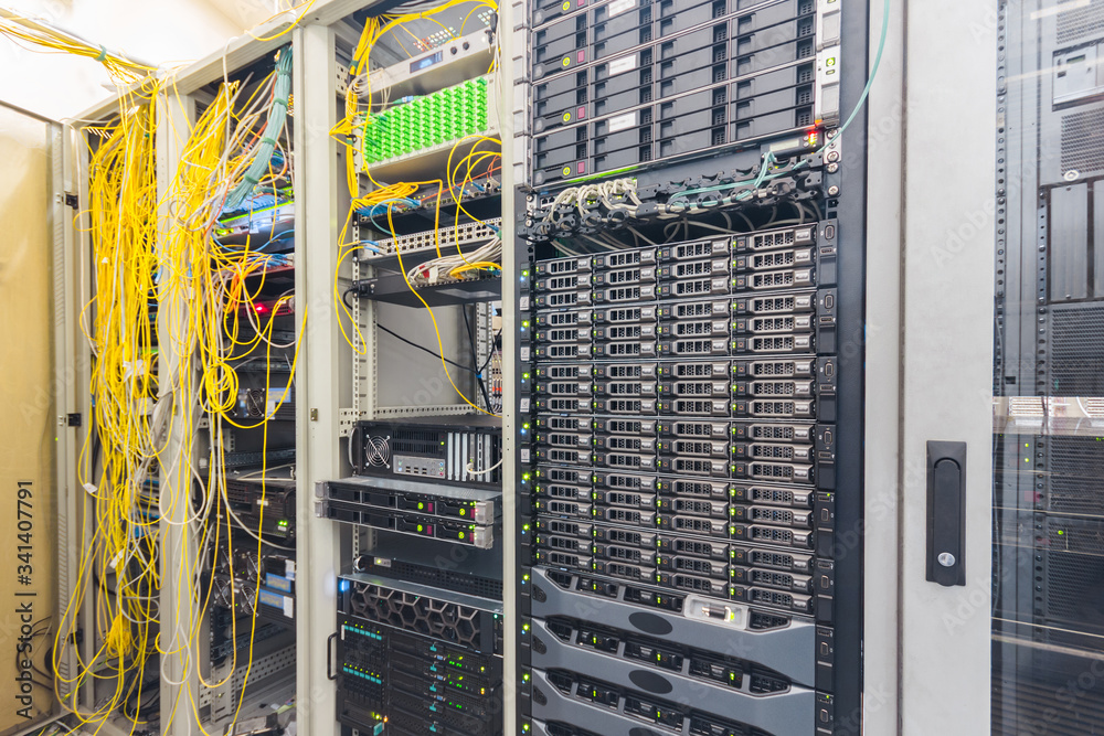 Powerful computing hardware works in the data center racks. Central  technical platform of the Internet provider. There is a lot of  telecommunications equipment in the server room. foto de Stock | Adobe