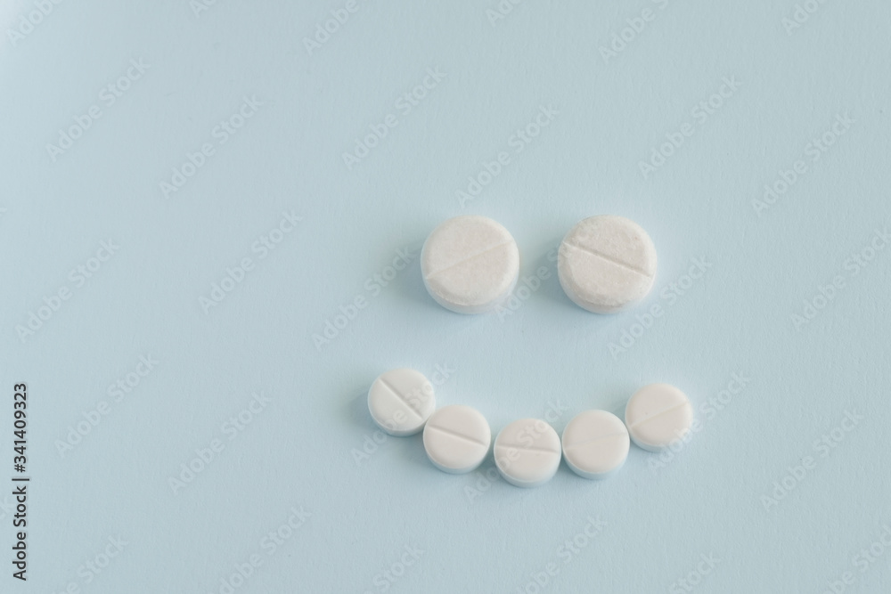 concept of good medicine. happy face made up of pills on blue backgroud concept of good medicine. happy face made up of pills on blue backgroud