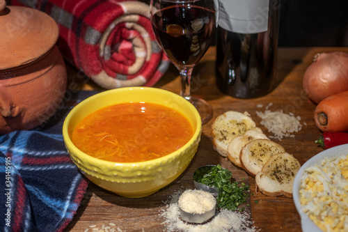 Canja de galinha. Portuguese soup with chicken and rice. Accompanied by toast, parsley, parmesan cheese and glass of wine photo