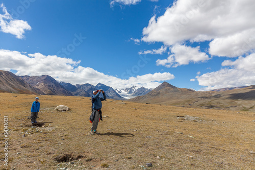Hiker young man and boy in the Altai mountains of Mongolia. Enjoy the scenery and take pictures of it.