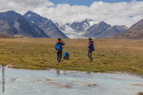 A family enjoy beautiful views of the mountains of the Mongolian Altai.