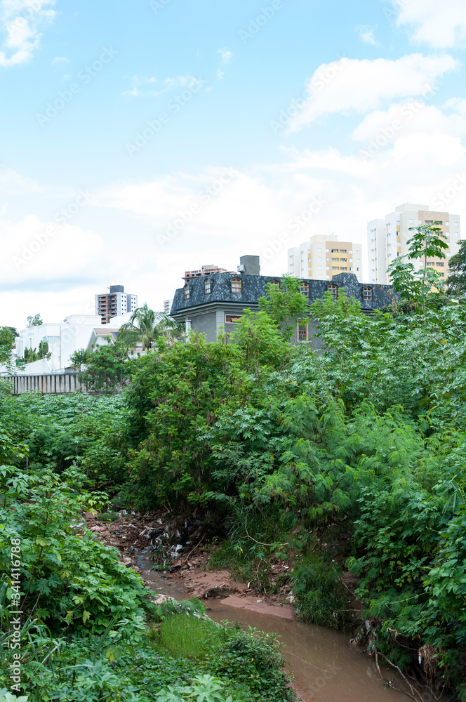 Obraz premium River full of trash and dirty btween city and ciliar forest