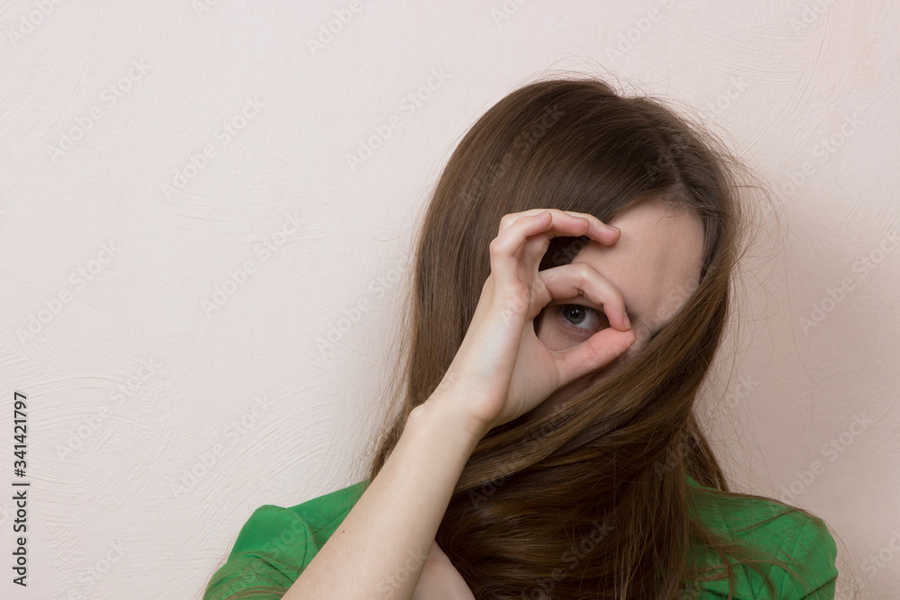 a long-haired girl hides her face behind her hair, only one of her eyes is visible. a long-haired girl hides her face behind her hair, only one of her eyes is visible.