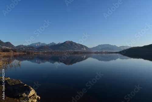 Alserio lake Como Italy - mountain reflected on the water - blue sky - Lago di Alserio