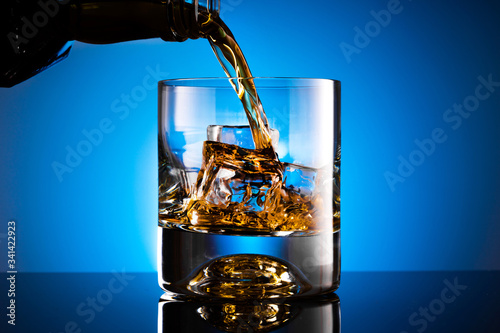 Glass of whiskey with ice cubes