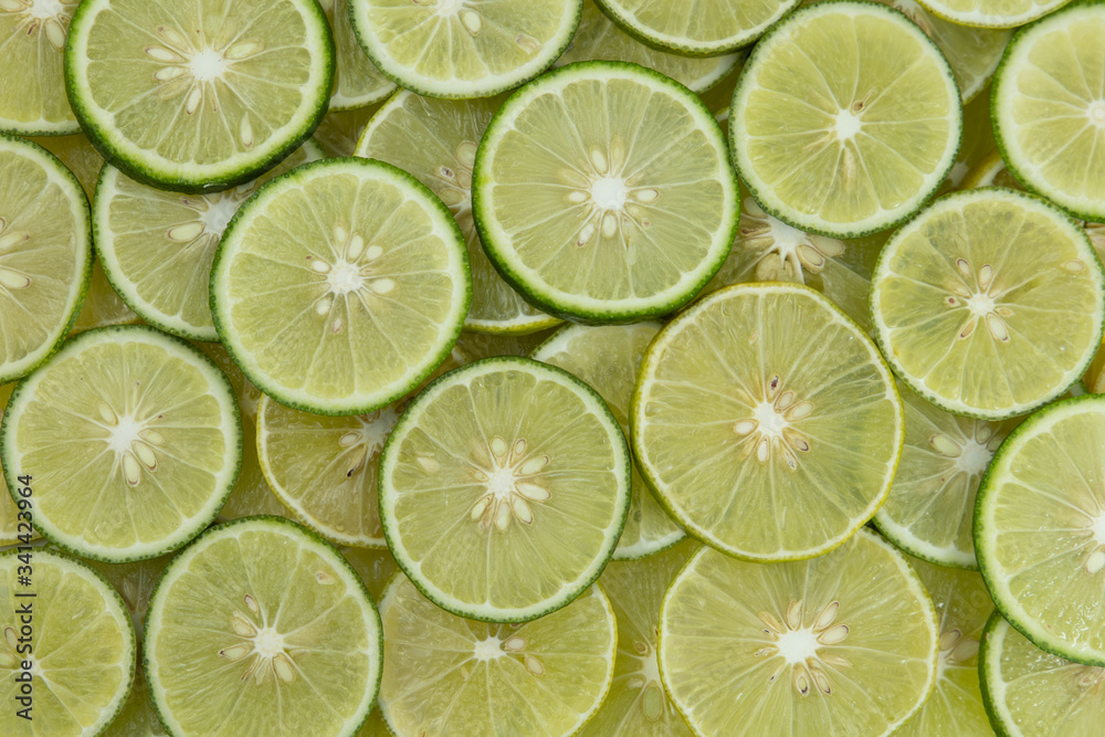 A slice of fresh juicy green lemons. Texture background, pattern.