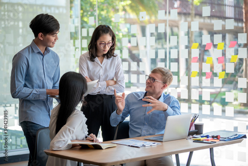 Teamwork of Asian business people discussing documents and plan financial graph analysis in the meeting room.