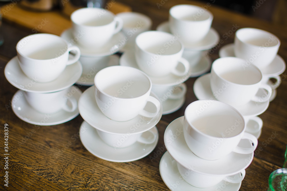 Stacked empty teacups with teaspoons at a function over Stacked empty teacups with teaspoons at a function over