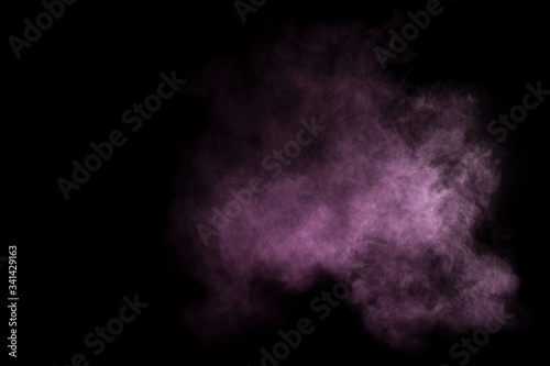 Purple powder explosion on black background. Colored powder cloud. Colorful dust explode. Paint Holi.