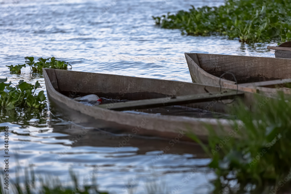 View of lake, aquatic vegetation and old wooden fishing boats on the banks View of lake, aquatic vegetation and old wooden fishing boats on the banks