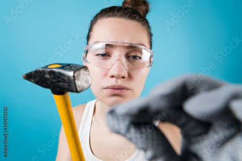 Obraz na płótnie Girl is going to hammer a nail into the camera