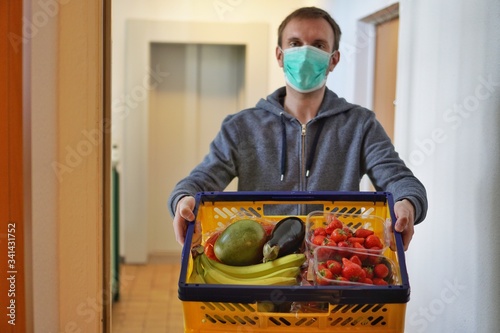 Lebensmittellieferung von Obst und Gemüse in Corona Krise vor die Haustür mit Schutzmaske wegen Virus Gefahr