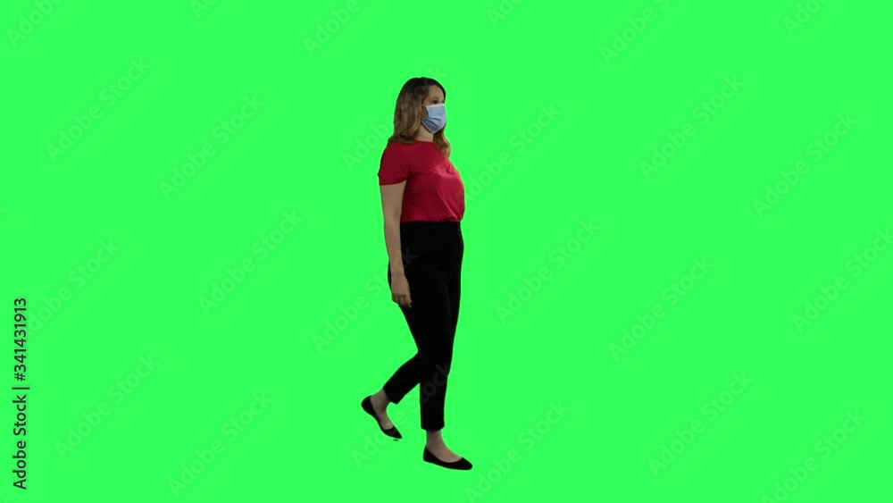 Woman with a surgical mask walking, waving hello, long shot over green screen. Woman with a surgical mask walking, waving hello, long shot over green screen.