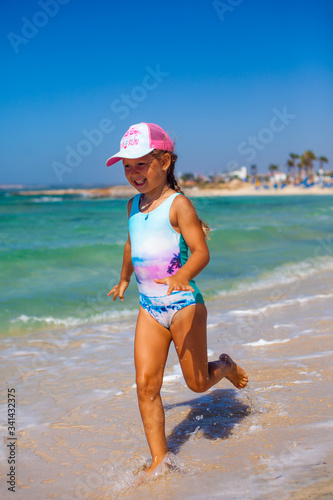 Little girl is on the beach in sunny day