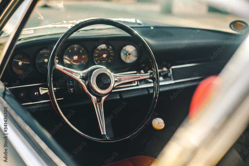 Control wheel and speedometer system of a retro car, view through window Control wheel and speedometer system of a retro car, view through window
