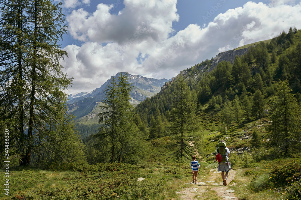 Little boy son went with his father on a hiking trip to the mountains.