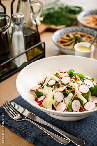 Mediterranean salad with thin sliced beetroot, lettuce, pomegranate tidbits and thin sliced greek cheese.  Authentic greek cuisine perivoli salad plating. photo