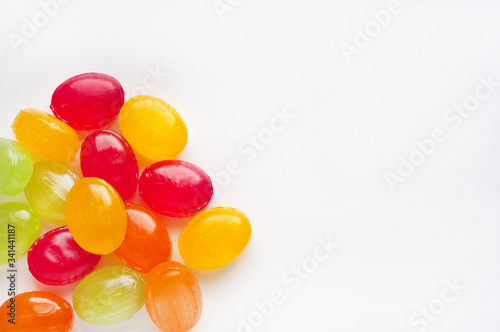Multi-colored caramel candies on a white background. Place for text. Yellow, red, green sweets.