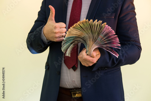 Male hands holding stack of ukrainian hryvnia banknotes isolated on green. Hryvnia new 1000 500 and 200 uah banknotes. photo